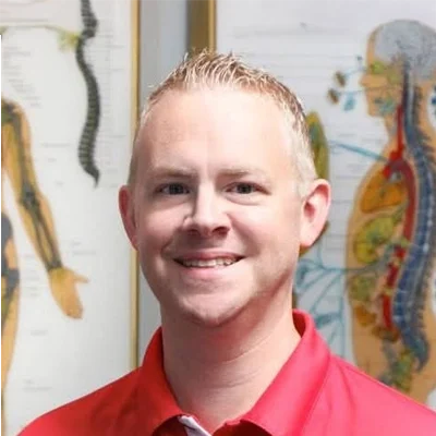 Chiropractor Vineland NJ Craig Evans Craig Evans smiling while wearing a red shirt.